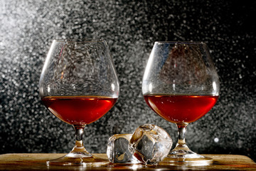 Pair of cognac glasses and ice cubes