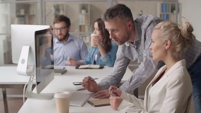 Head of the team telling his colleague what she needs to correct