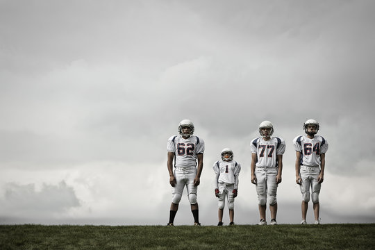 Four football players standing on the field