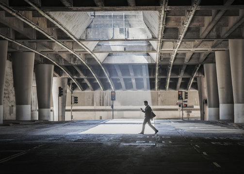 A young man walking in city underpass
