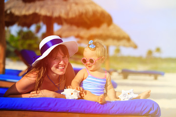 mother and cute little daughter having fun on beach