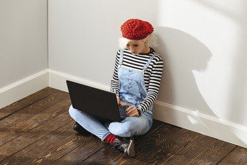 cute blond lady with a laptop in an empty room