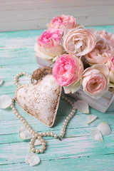 Pink roses in wooden pot, decorative heart and pearls