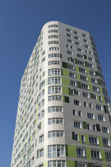 Fototapeta na wymiar The new inhabited multi-storey building against a clear sky