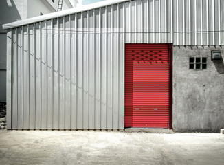 Industrial warehouse with a single red roller door 