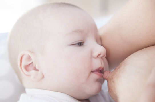 View of baby head getting close to the nipple