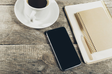 Smart phone with notebook and cup of strong coffee