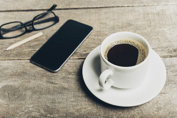 Smart phone with notebook and cup of strong coffee