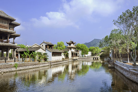 Traditional white Chinese houses reflected in a tranquil canal, Hengdian, China
