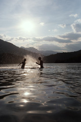 Silhoueted young couple at the beach on a hazy summer day at dus