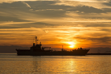 Fototapeta premium Bulk-carrier ship at sunset in the sea