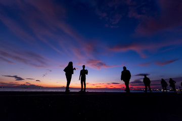 The Silhouettes are doing Activities on the Beach at Sunset