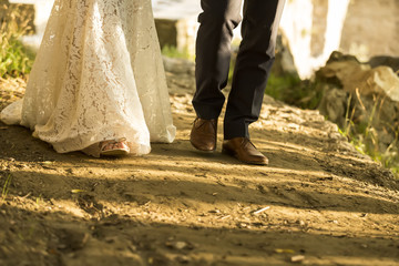 feet of bride and groom walking, wedding shoes (soft focus). Cro