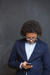 Typing message. Handsome young man with afro hair in shirt holdi