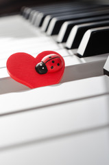 Red heart on piano keyboard