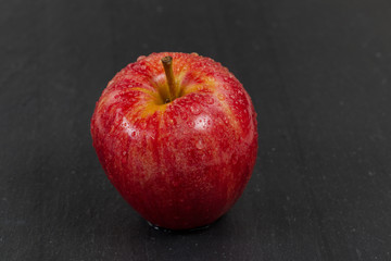 Fresh red whole apple on black slate stone background