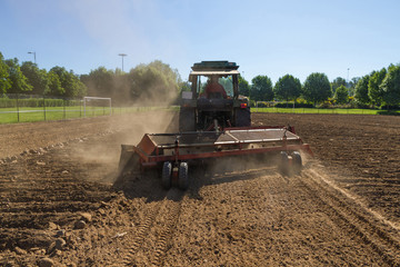 Fototapeta premium Tractor con Rastrillo Mecanico para Recoger Piedras de la Tierra 