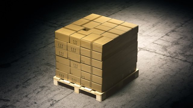 A stack of cardboard boxes on a pallet in the warehouse waiting for a forklift.