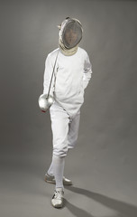 Full length of a foil fencer on gray background.