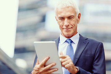 Senior businessman holding touchpad 