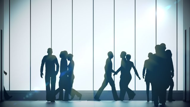 Silhouettes of a crowd of backlighted people walking in bright spacious lobby.