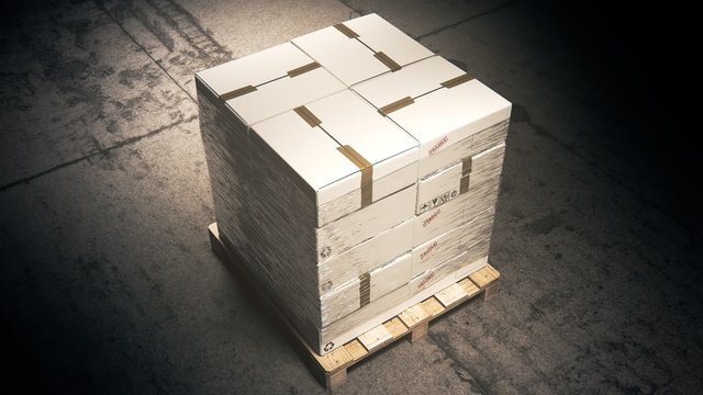 A stack of cardboard boxes on a pallet in the warehouse waiting for a forklift.