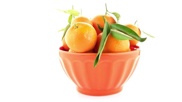 Tangerines on ceramic orange bowl  isolated on white background