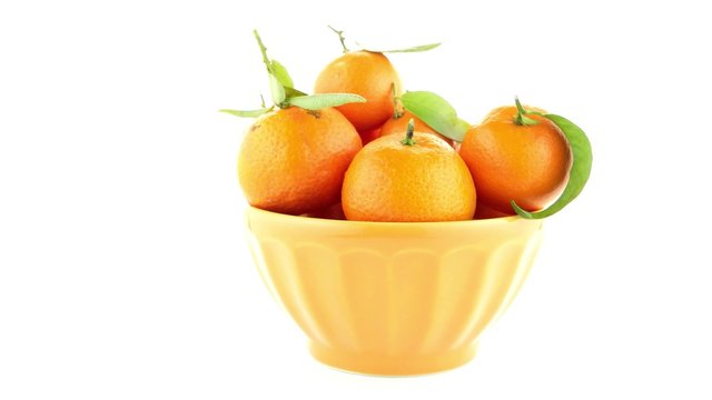Tangerines on ceramic yellow bowl  isolated on white background
