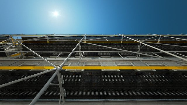 A scaffold structure connected to the facade at the construction site.