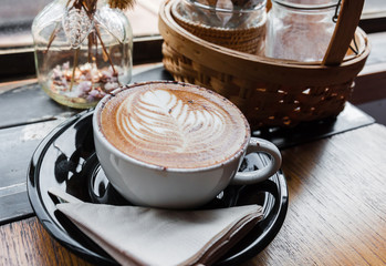 A cup of cappucino on a wood table
