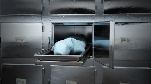 Close up on the opened locker in the morgue. A dead body covered with cloth.