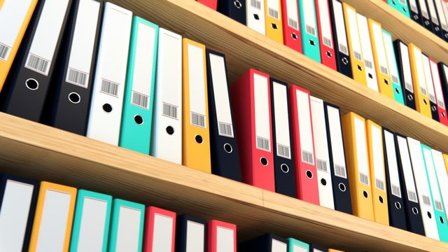 Close up on the row of the file colorful binders stacked on the wooden shelf.