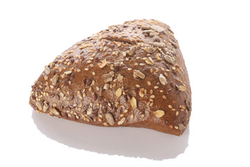 Brown bun sprinkled with flax seeds, sunflower, pumpkin and sesa