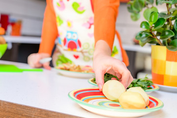 Woman grab peeled potato by hand,in modern kitchen