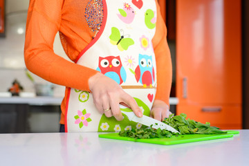 Woman cutting salad in the kitchen