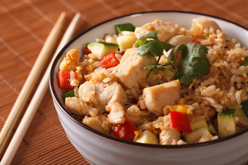 Fototapeta na wymiar Japanese food: fried rice with chicken and vegetables close up. Horizontal 