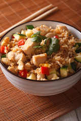 Japanese food: fried rice with chicken and vegetables close up. vertical
