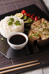 Asian Cuisine: Steak white fish, rice and sauce close-up. Vertical
