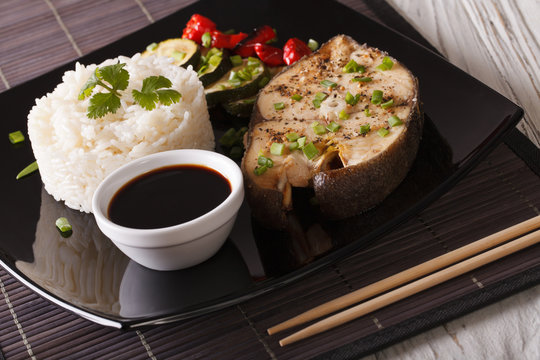 Asian Cuisine: Steak white fish, rice and sauce close-up. horizontal
