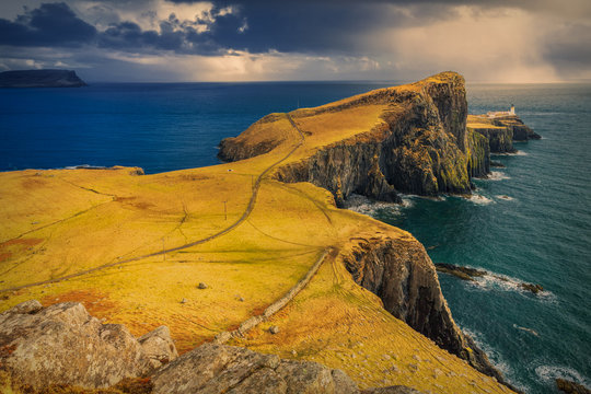 Dramatic cloudy and rainy sky over Neist Point and its lighthouse on Isle of Skye, Scotland, UK