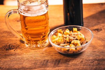  glass of fresh bright beer and crackers on wooden table