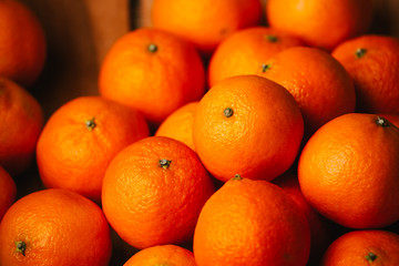 many fresh tangerines on a wooden background