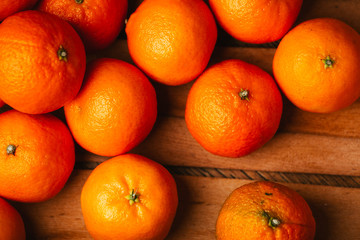 many fresh tangerines on a wooden background