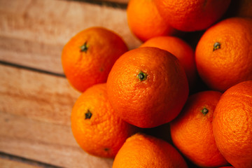many fresh tangerines on a wooden background