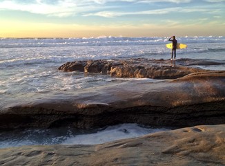  Lonely surfer checks out the surf along the shoreline
