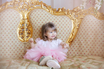 Little girl sitting on a luxury sofa