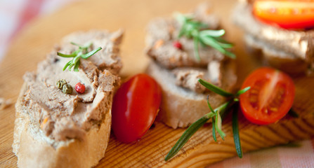 Chicken liver pate on bread with cherry tomatoes and a sprig of rosemary