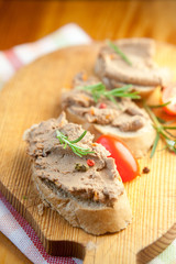 Chicken liver pate on bread with cherry tomatoes and a sprig of rosemary 