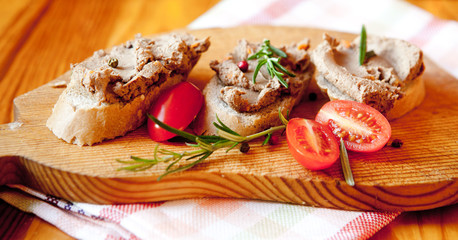 Chicken liver pate on bread with cherry tomatoes and a sprig of rosemary 