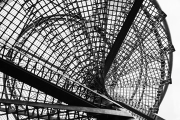 Metal spiral ladder, black silhouette over sky